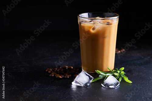 Tasty ice coffee with milk , cold drink in glass on dark background photo