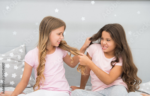 Unhand my hair. Naughty children pull on hair. Beauty look of little girls. Hair salon. Home clothing and leisure wear. Haidressing and styling. Because its my hair photo