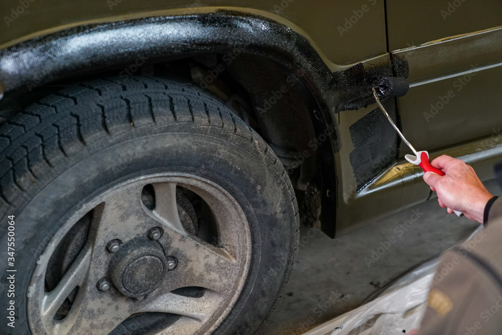close up of a soldier painting an army jeep and adding black trim close up of a soldier painting an army jeep and adding black trim