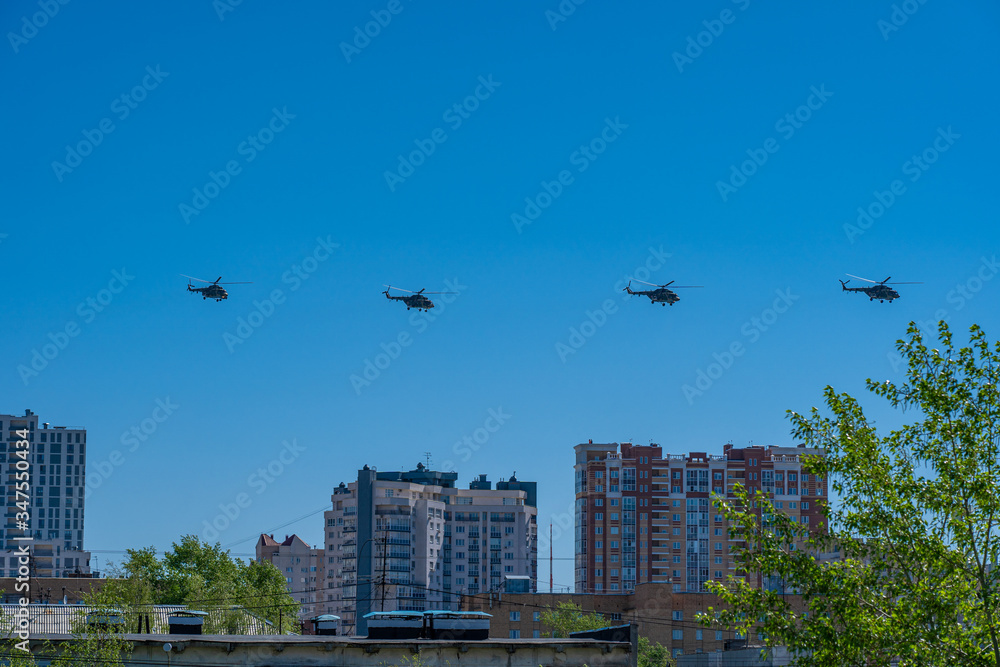 Four helicopters of russian air forces are flying in a row on bright blue sky Four helicopters of russian air forces are flying in a row on bright blue sky