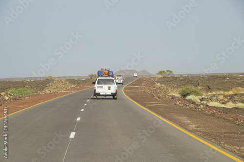 Travel across Africa. Road on lava field. Convoy of offroad vehicles drive through Danakil Desert. One of the lowest and hottest places on Earth. Ethiopia, Afar Depression (Afar Triangle)