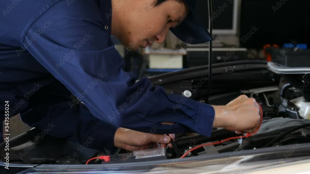 male mechanics check electrical wiring vehicle system in a car service