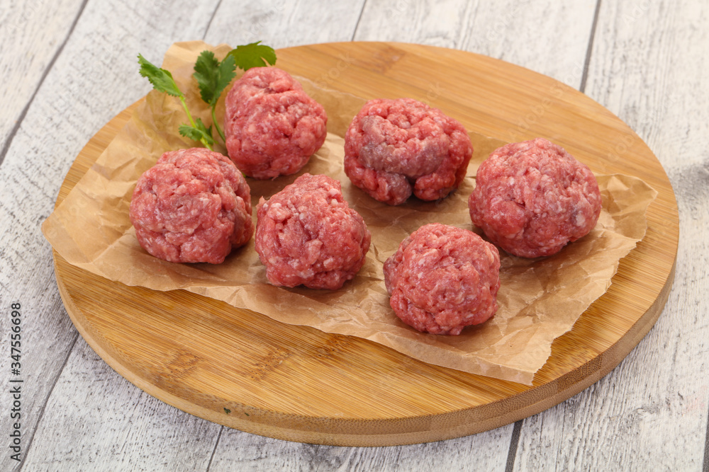 Raw meatball over wooden background Raw meatball over wooden background