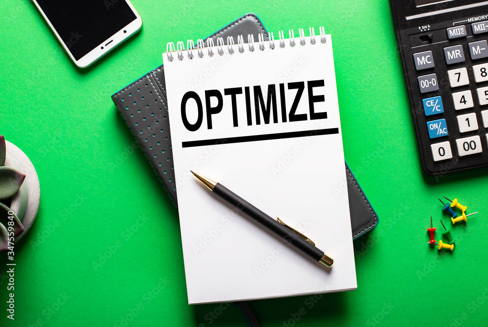 The word optimize is written on a white sheet on a green background next to a potted flower The word optimize is written on a white sheet on a green background next to a potted flower