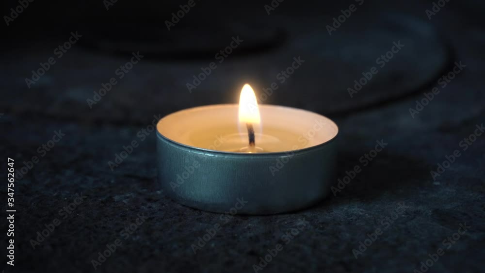 4K of small circular candle with burning flame. Single candle with glowing fire 4K of small circular candle with burning flame. Single candle with glowing fire