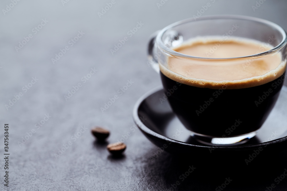 Coffee in glass cup on dark stone background. Close up. Coffee in glass cup on dark stone background. Close up.