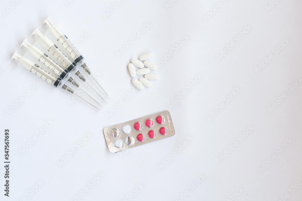 pills and syringes on a white background pills and syringes on a white background