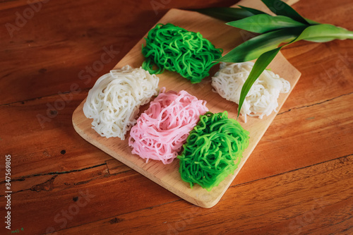 Food Photography Petulo (Putu Mayan g) is Traditional Javanese food of rice flour strands curled up into a ball; eaten with coconut milk and palm sugar. photo