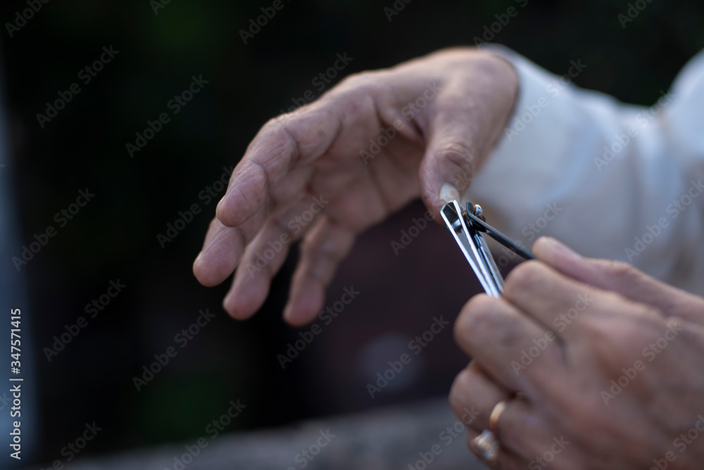 man cutting his nails by a nail cutter on rooftop outdoor. Covid, Lock down and Home isolation