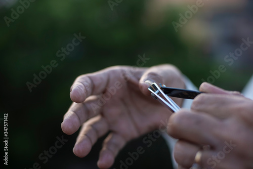 man cutting his nails by a nail cutter on rooftop outdoor. Covid  Lock down and Home isolation