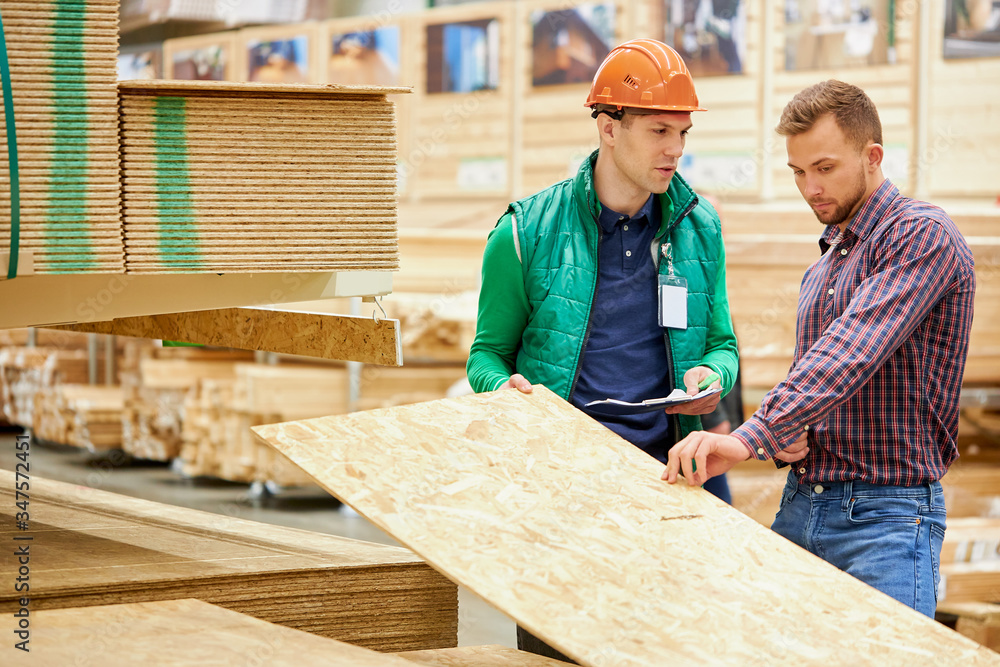 handsome man consults with warehouse worker in uniform, which size of wooden board will be suitable handsome man consults with warehouse worker in uniform, which size of wooden board will be suitable