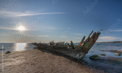 Shipwreck of the fore-and-aft schooner Raketa  built in Rauma  Finland in the post war years for the Soviet Union as compensation for war damages. Sunset time  sun falls to the sea. Estonian coast.