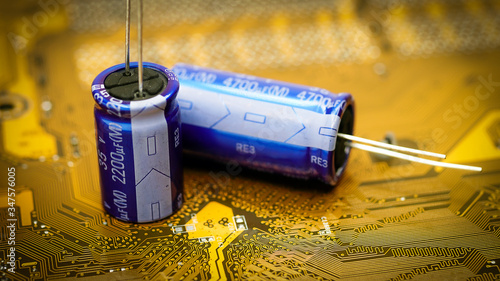 Electronic capacitor on a golden printed circuit board photo