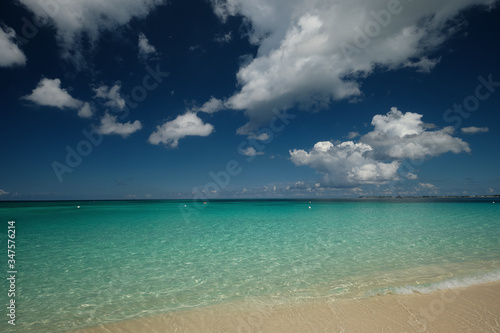Fototapeta Naklejka Na Ścianę i Meble -  Crystal clear waters and pinkish sands on empty seven mile beach on tropical carribean Grand Cayman Island