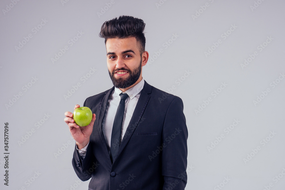young handsome black hair man in stylish business suit eating green apple in studio isolate white background young handsome black hair man in stylish business suit eating green apple in studio isolate white background