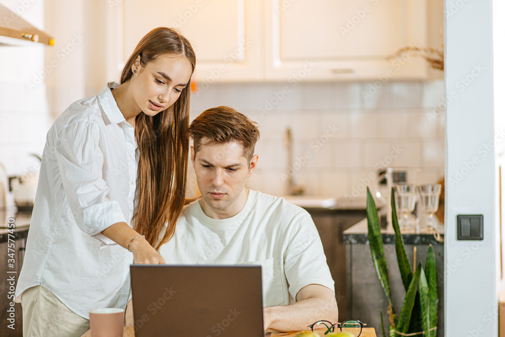 young caucasian married couple looking for their first purchase online on laptop. beautiful wife and husband want to get mortgage young caucasian married couple looking for their first purchase online on laptop. beautiful wife and husband want to get mortgage
