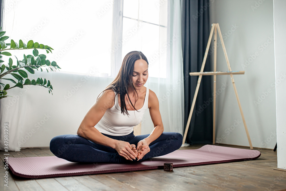 young and slender caucasian woman stretching at home, woman in sport clothes doing exercises at home during quarantine young and slender caucasian woman stretching at home, woman in sport clothes doing exercises at home during quarantine