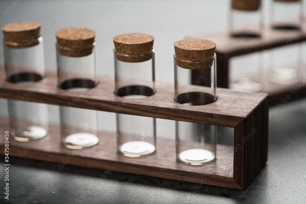 empty walnut holder with glass tubes for spices on concrete surface empty walnut holder with glass tubes for spices on concrete surface