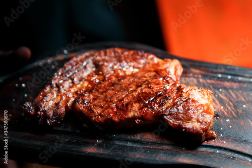 A thick juicy portion of fried fillet of steak is served on an old wooden boar.