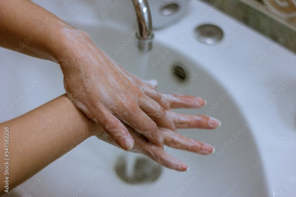 To prevent a coronavirus pandemic, a girl washes her hands with soap and water, proper washing and handling of an antiseptic will protect against the virus. To prevent a coronavirus pandemic, a girl washes her hands with soap and water, proper washing and handling of an antiseptic will protect against the virus.