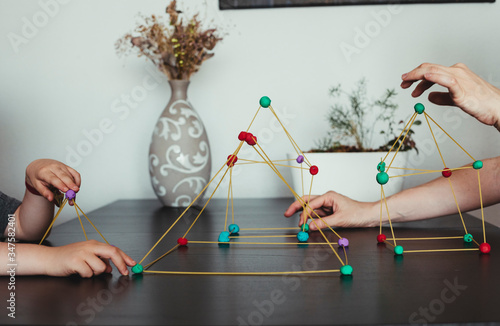 Mother and son  making geometric shapes from sticks and play dough.