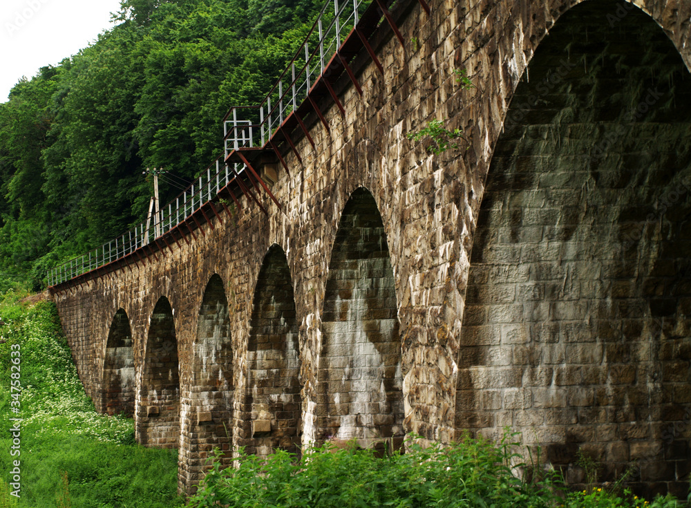 old stone bridge overpass railway train forest mountains ancient arch