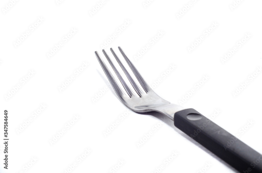 metal fork with a black handle on a white background metal fork with a black handle on a white background