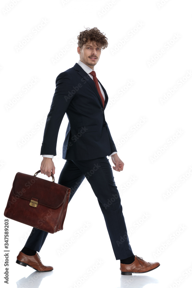 Side view of motivated businessman holding his briefcase Side view of motivated businessman holding his briefcase