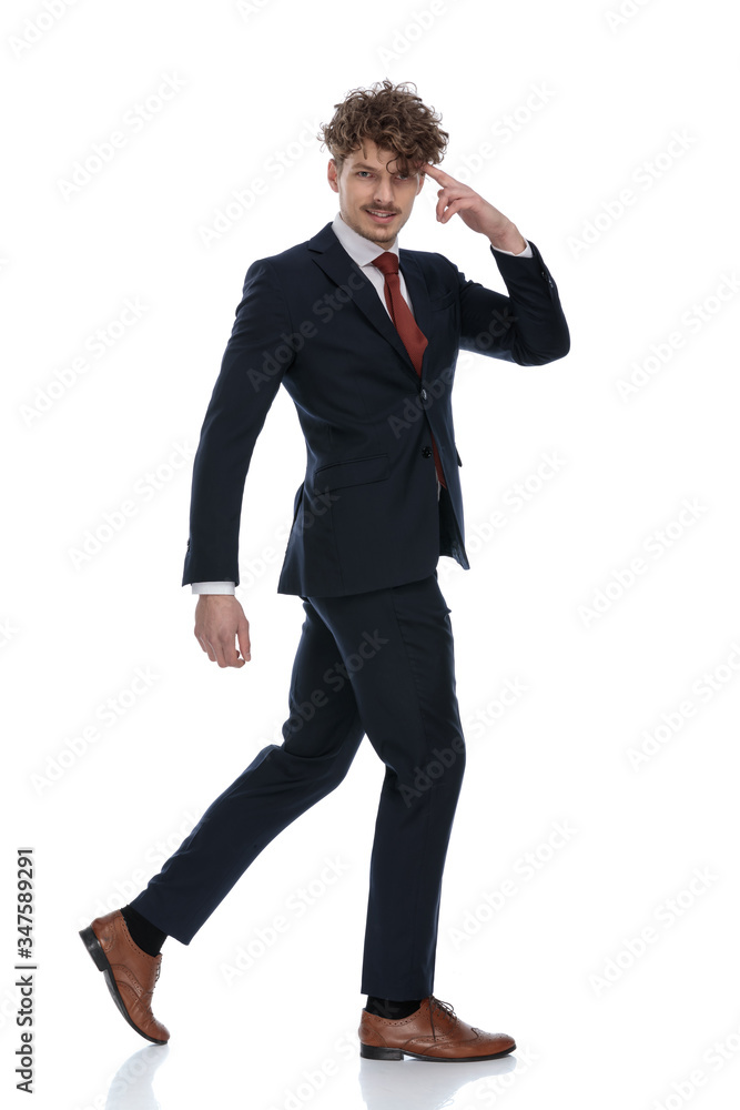 Side view of smiling businessman pointing to his head Side view of smiling businessman pointing to his head
