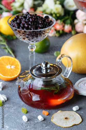 Fruit tea with mint, oranges and cranberries on a decorative background. Hot winter drinks. A teapot of hot tea