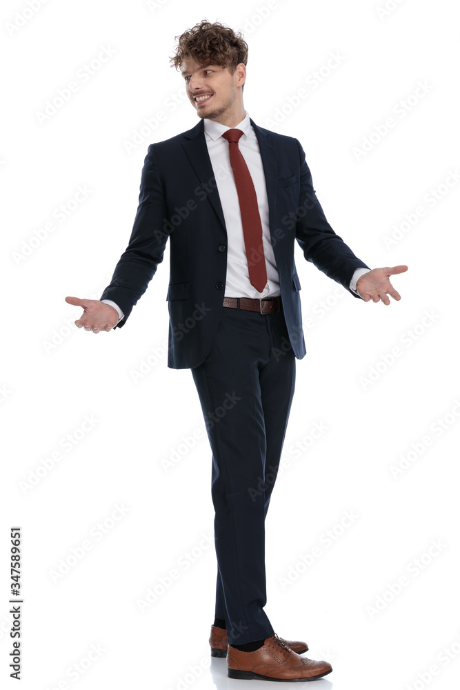 Side view of positive businessman looking over shoulder and explaining Side view of positive businessman looking over shoulder and explaining