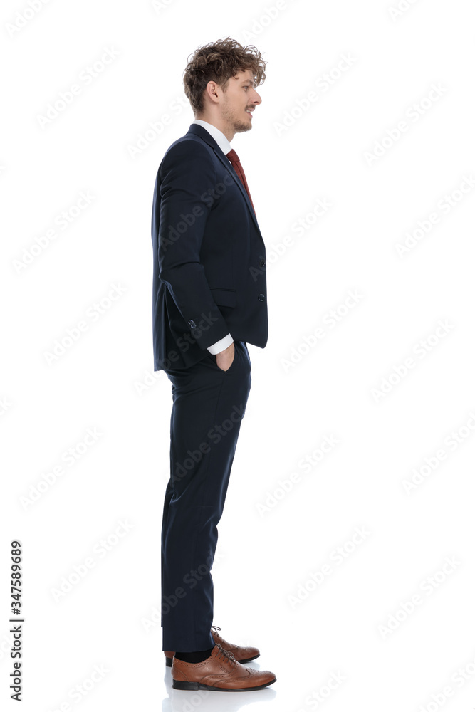 Side view of positive businessman smiling with hand in pocket Side view of positive businessman smiling with hand in pocket