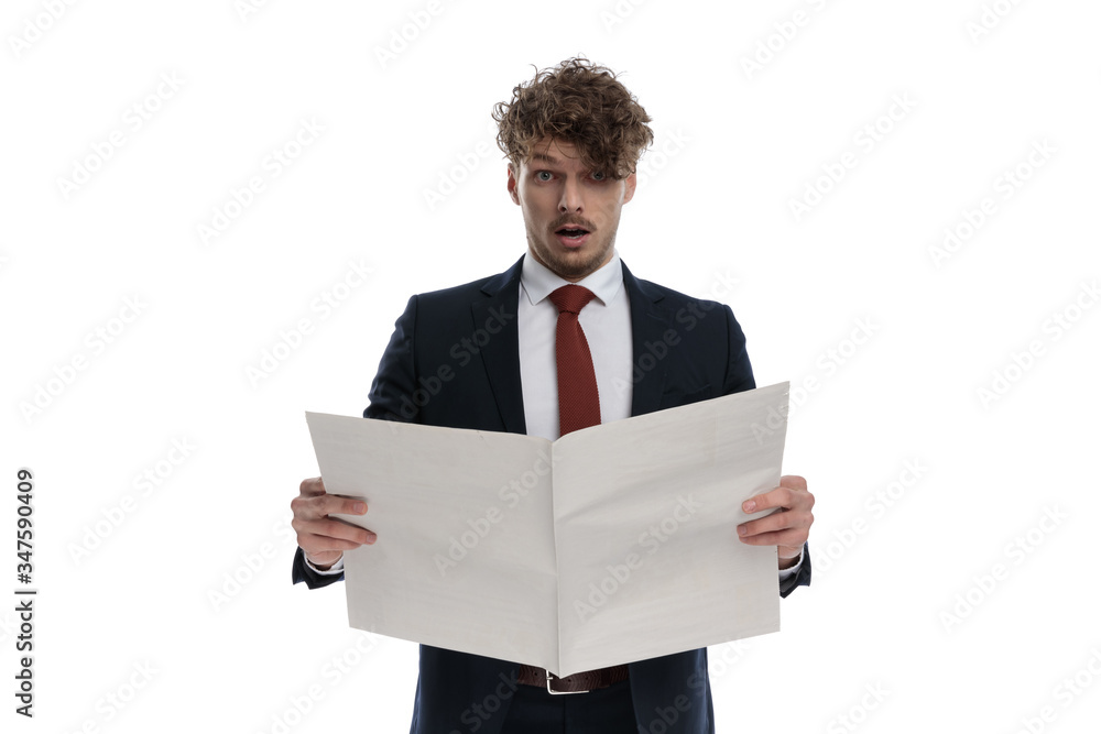 Surprised businessman reading newspaper and gasping Surprised businessman reading newspaper and gasping