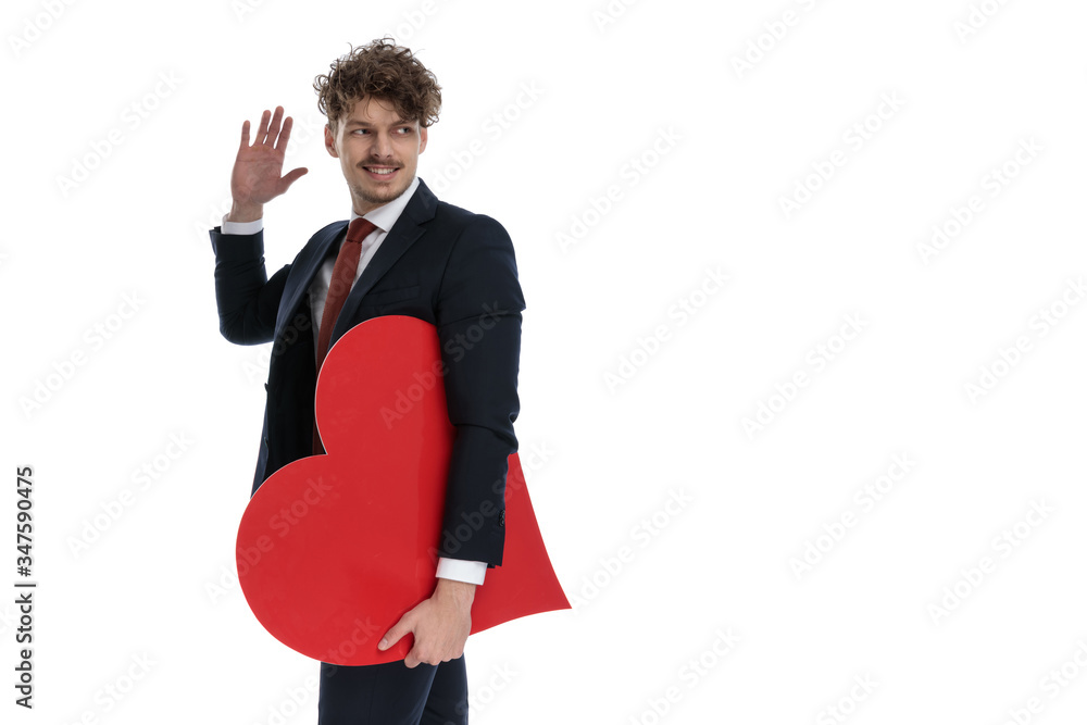 Happy businessman holding heart shape, smiling and waving Happy businessman holding heart shape, smiling and waving