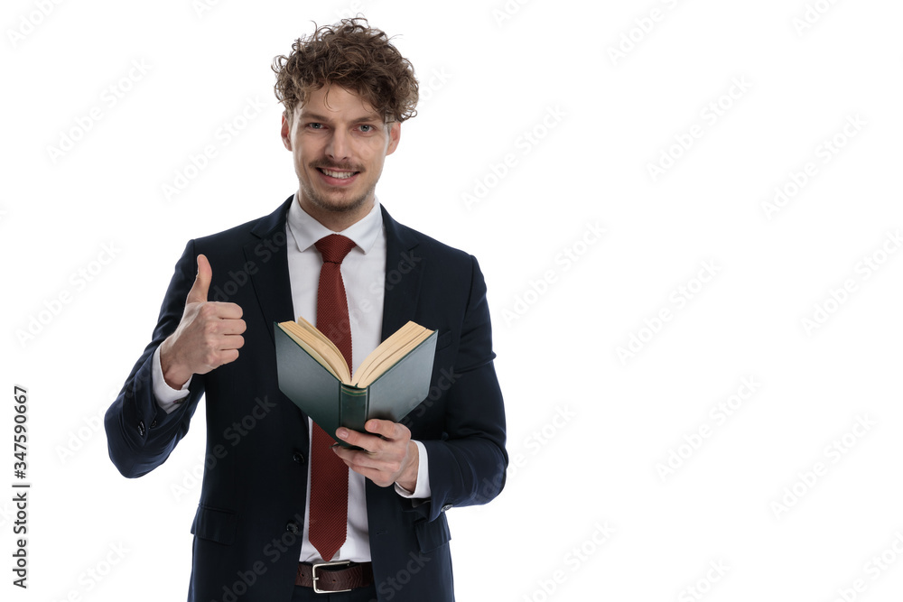 Positive businessman holding book and gesturing ok Positive businessman holding book and gesturing ok