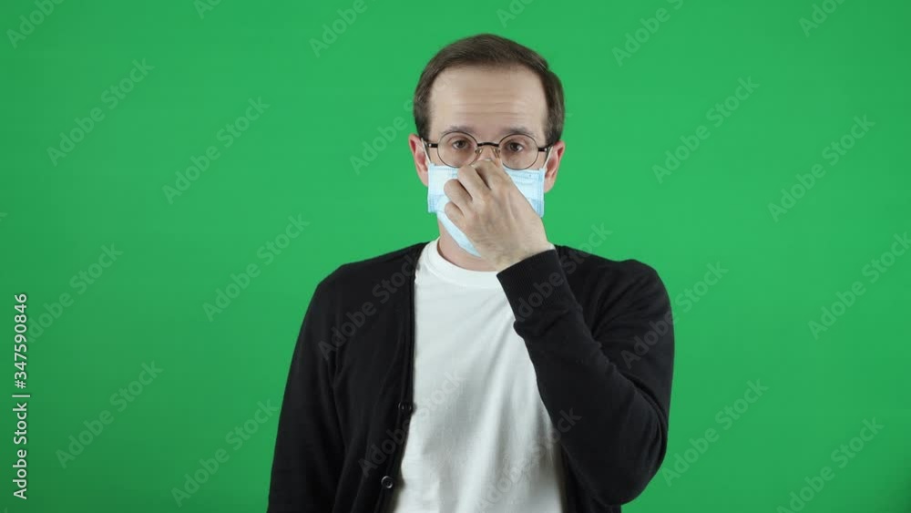 Quarantine continues, extended. A young man of European appearance. Wearing a respiratory, medical mask. With a sign and an inscription in Russian Quarantine continues, extended. A young man of European appearance. Wearing a respiratory, medical mask. With a sign and an inscription in Russian