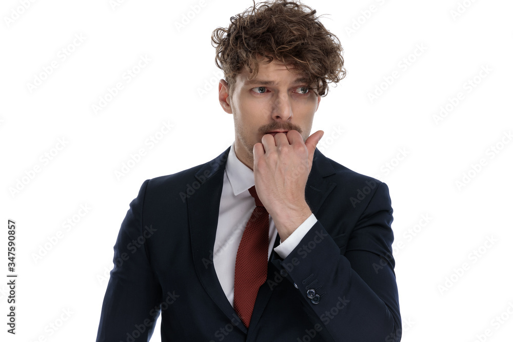 Afraid businessman looking away with hand on chin Afraid businessman looking away with hand on chin