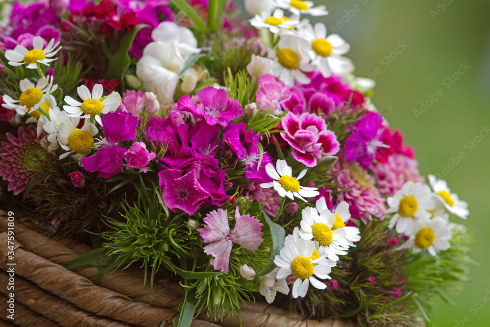 Sommerliches Blumengesteck in einem Weidenkorb Sommerliches Blumengesteck in einem Weidenkorb
