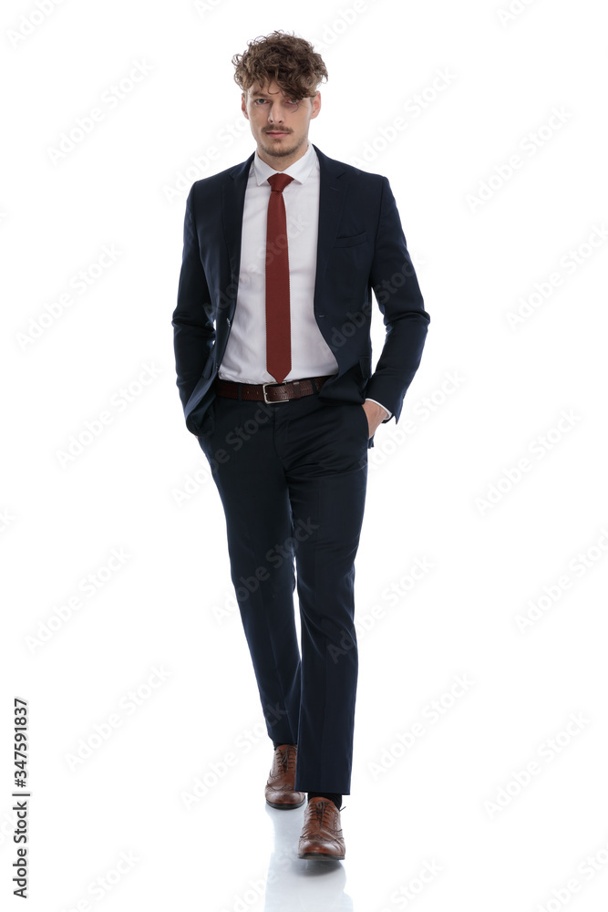 Serious businessman holding both hands in his pockets Serious businessman holding both hands in his pockets