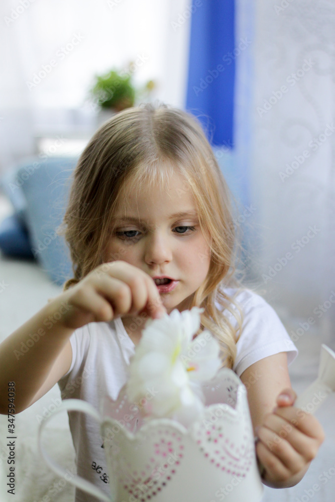girl watering flowers from a watering can girl watering flowers from a watering can