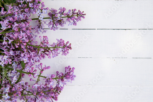 Flower composition. Frame of lilac flowers on a white wooden background. Flat lay, space for text.