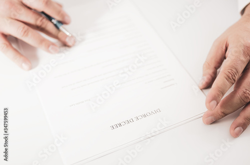 Closeup of a man preparing to fill out and sign a divorce decree