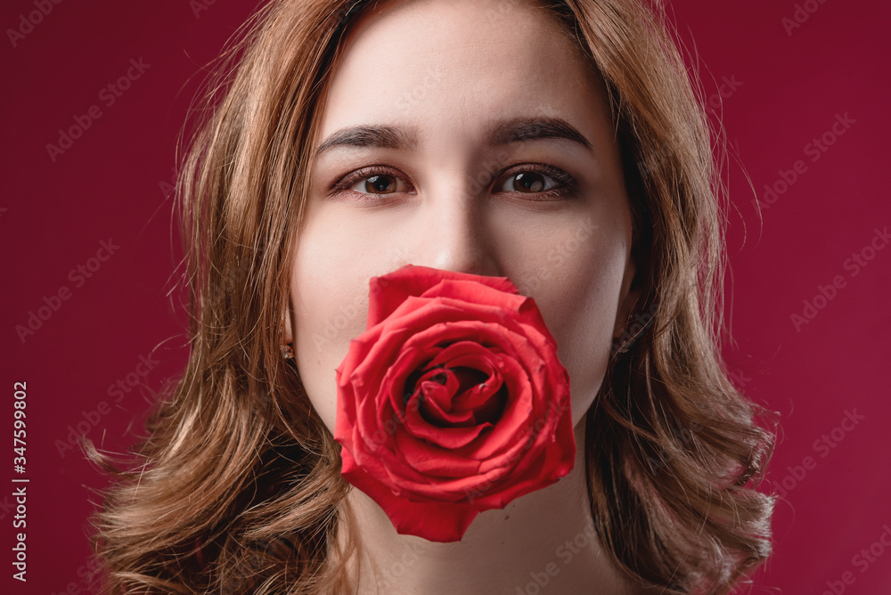 Portrait of a beautiful girl with bare shoulders and a rose. The concept of youth, beauty and a healthy body Portrait of a beautiful girl with bare shoulders and a rose. The concept of youth, beauty and a healthy body