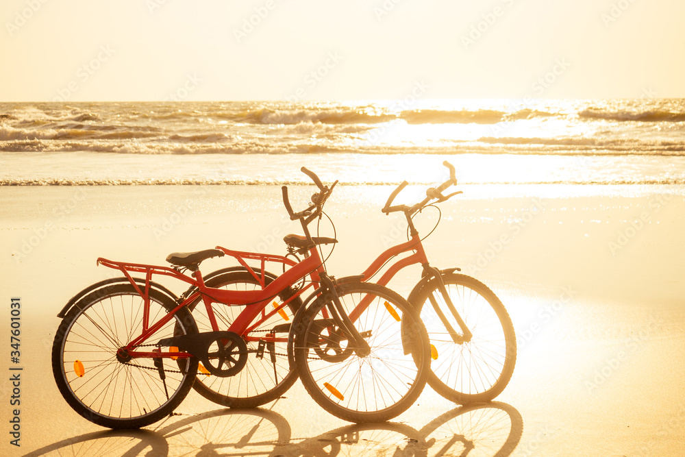 two bicycles and empty beach without people.no body at sunset