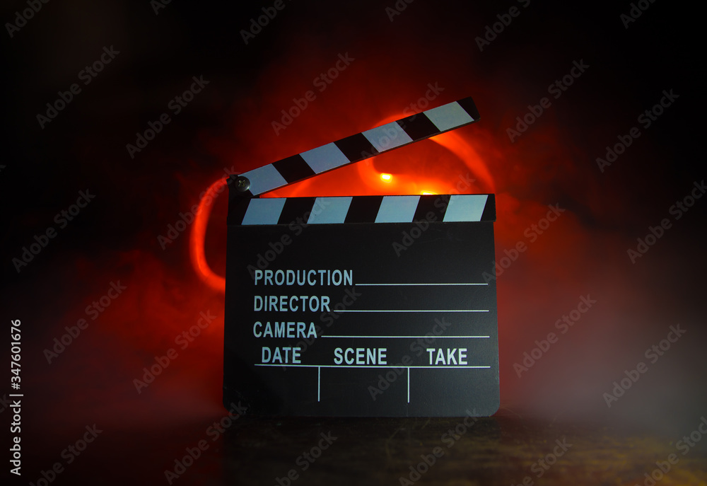 Obraz premium Movie concept. Miniature movie set on dark toned background with fog and empty space. Silhouette of vintage camera on tripod.