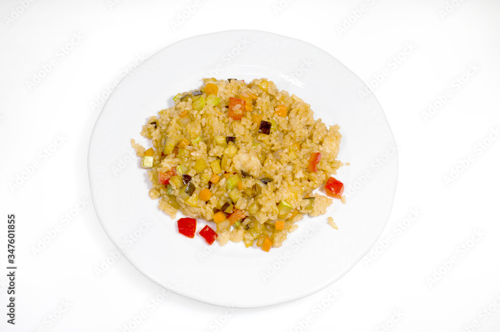 Boiled rice with slices of vegetables on a white plate on a white background Boiled rice with slices of vegetables on a white plate on a white background