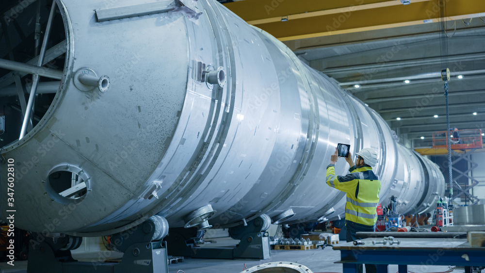 Heavy Industry Engineer Uses Augmented Reality Digital Tablet to Scan Large Diameter Pipe. Modern Industrial Manufacturing Technology to Design and Construct Oil, Gas and Fuels Transport Pipeline. Heavy Industry Engineer Uses Augmented Reality Digital Tablet to Scan Large Diameter Pipe. Modern Industrial Manufacturing Technology to Design and Construct Oil, Gas and Fuels Transport Pipeline.