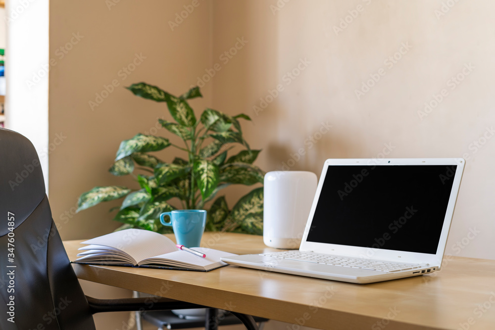Telecommuting job from home. Photography of a laptop whit black screen. Mockup. A notebook in the desk and an intelligent lamp. Telecommuting job from home. Photography of a laptop whit black screen. Mockup. A notebook in the desk and an intelligent lamp.