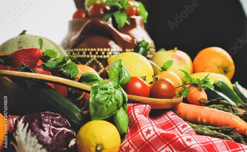full frame of a rustic composition of fruit and vegetables arranged on a table