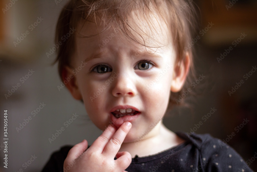 Close-up portrait of a little cute white baby with a dirty face in soft light and blurry background Close-up portrait of a little cute white baby with a dirty face in soft light and blurry background
